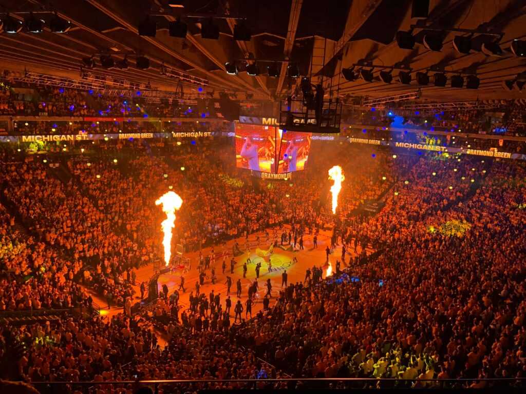 Lively basketball event with a huge crowd and fiery show in Oakland arena, capturing the vibrant sports atmosphere.