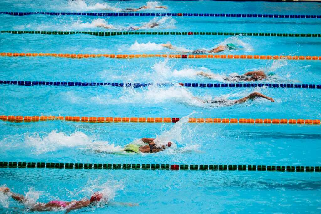 Swimmers compete in an outdoor pool race, showcasing athleticism and sportsmanship.
