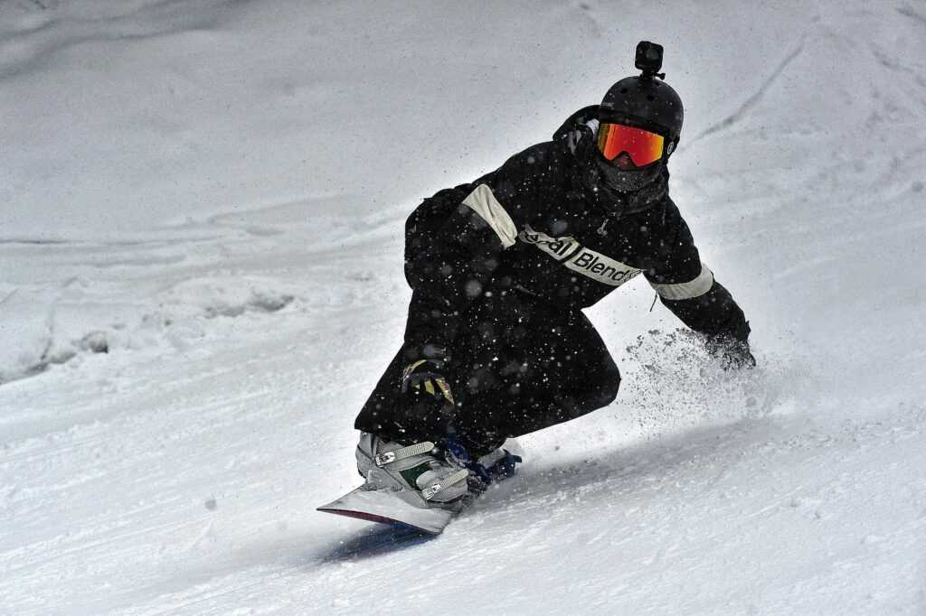 A skier in full gear carving through fresh snow on a winter slope, showcasing speed and skill.